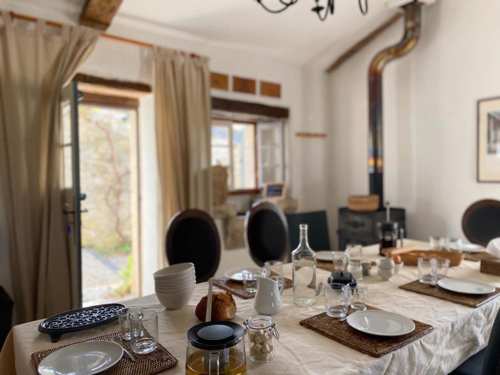une table avec des assiettes et des verres au-dessus dans l'établissement Gîte de charme avec grand jardin & piscine, à Touffailles