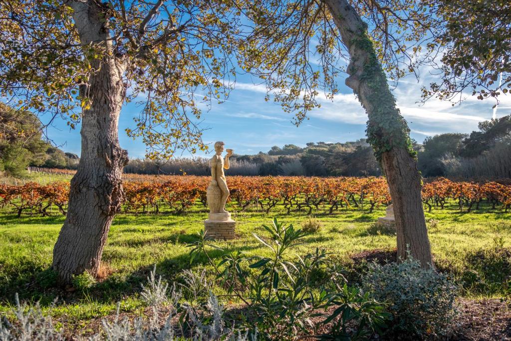 a statue in the middle of a field with trees at Hôtel Helios &amp; SPA - Ile des Embiez in Six-Fours-les-Plages