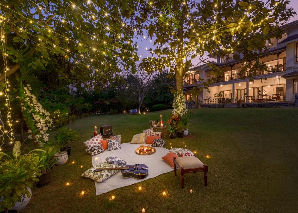 a picnic table in a yard with lights at SaffronStays Mograa laffaire in Alibaug