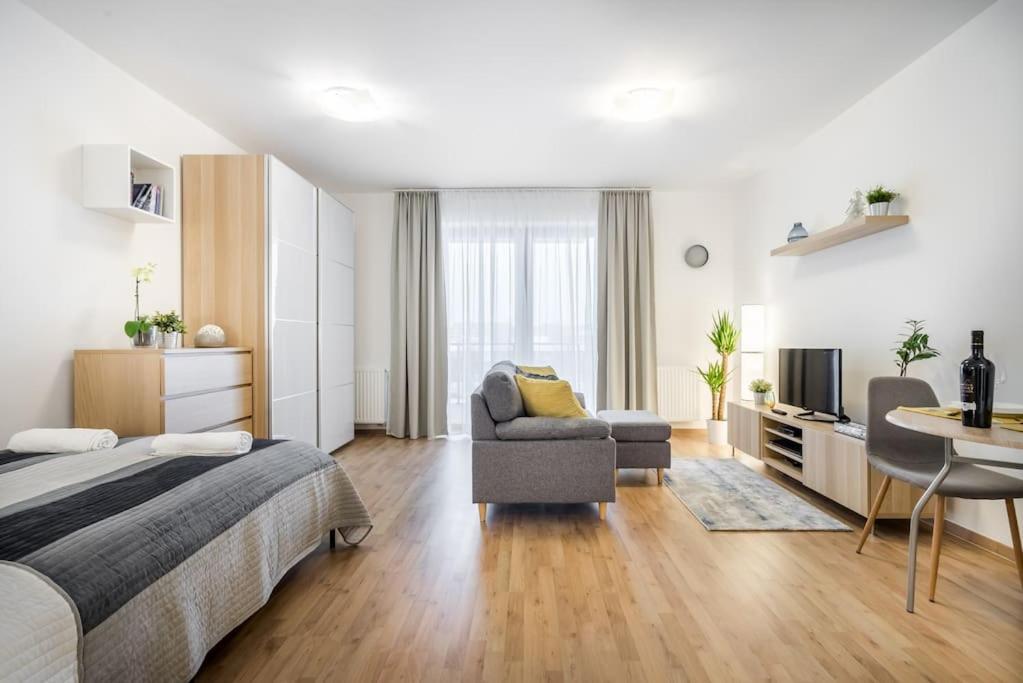 een slaapkamer met een bed, een stoel en een tafel bij Marina apartment at Danube - FREE PRIVATE PARKING! in Boedapest