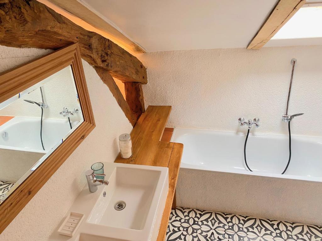 a bathroom with a bath tub and a sink at Gîte de charme avec grand jardin &amp; piscine in Touffailles