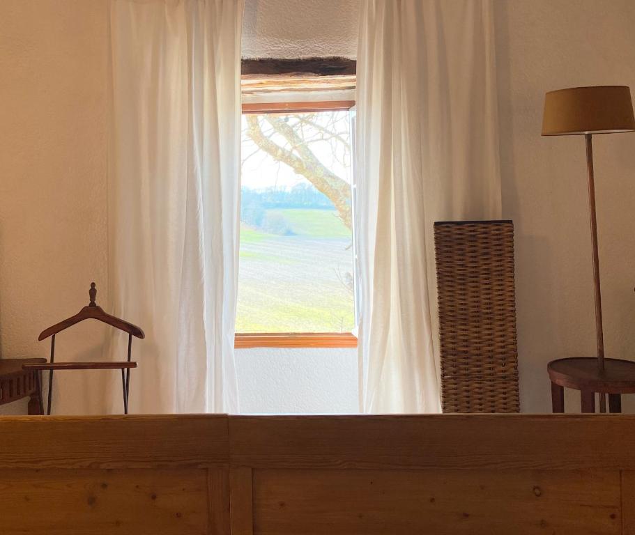 a large window with white curtains in a room at Gîte de charme avec grand jardin &amp; piscine in Touffailles