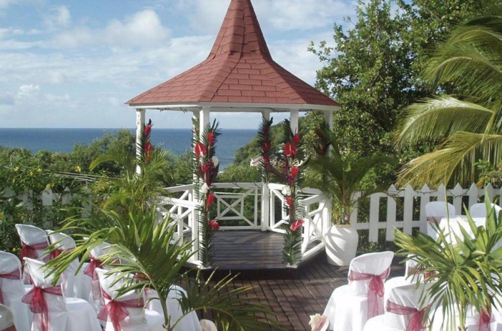 a gazebo with christmas decorations in front of the ocean at Amazing 9 BR Villa in Cap Estate in Cap Estate