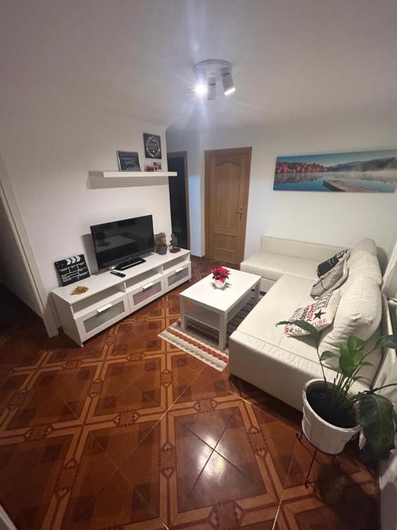 a living room with a couch and a flat screen tv at Habitación privada en piso compartido Madrid in Madrid
