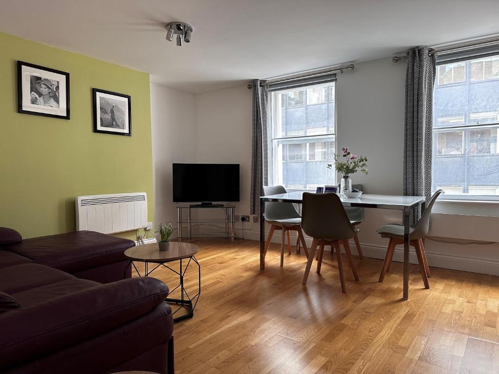 a living room with a couch and a table with chairs at Apt 3, Soho Apartments 2nd & 3rd floors by Indigo Flats in London