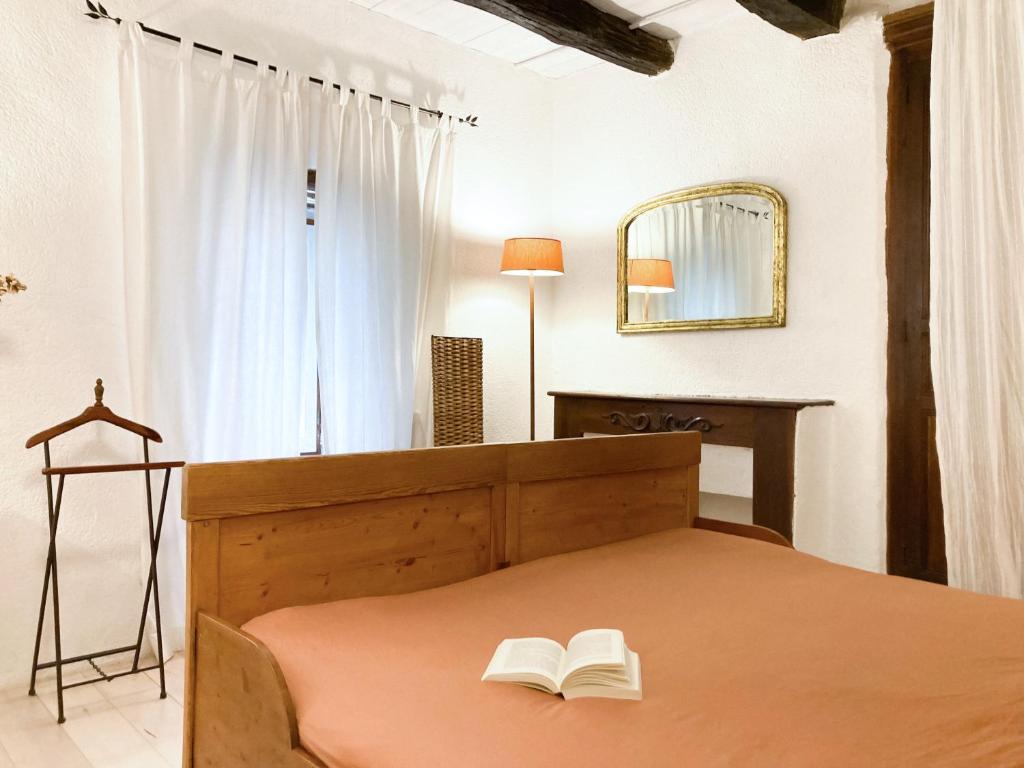 a bedroom with a bed with two books on it at Gîte de charme avec grand jardin &amp; piscine in Touffailles