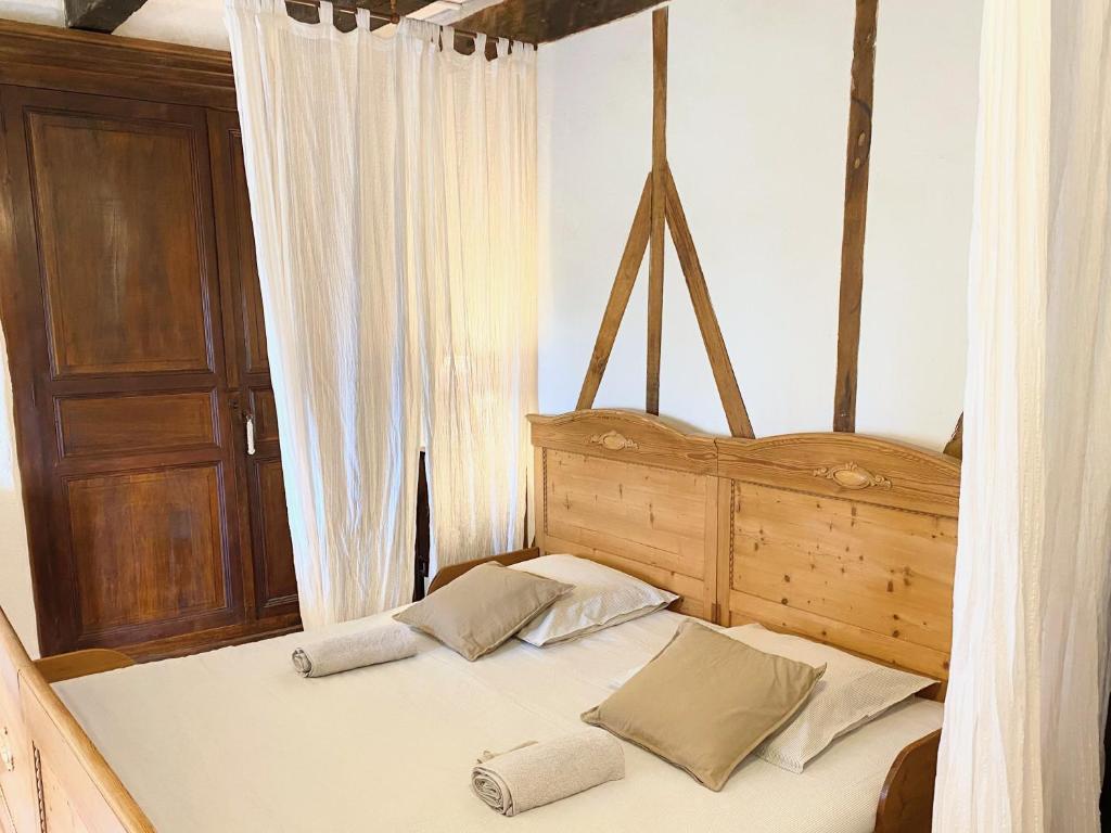 a bed with two pillows on it in a bedroom at Gîte de charme avec grand jardin &amp; piscine in Touffailles