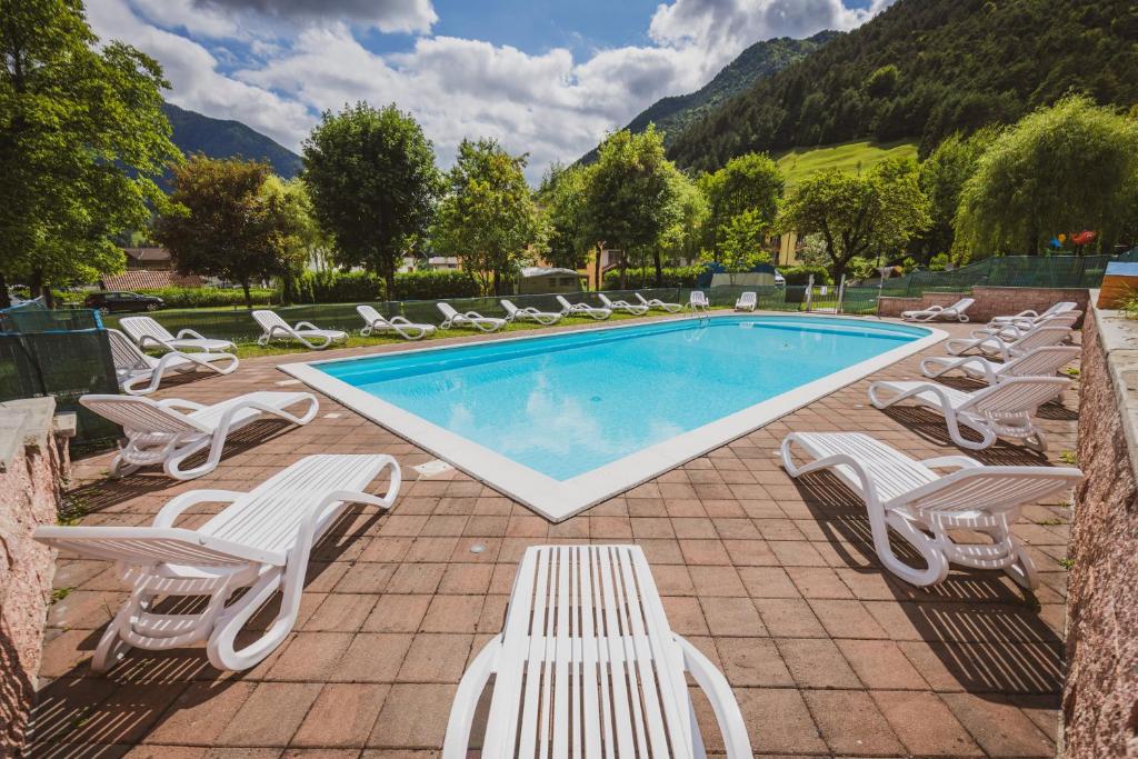 a pool with chaise lounge chairs and a bunch ofvisorvisorvisor at Camping Casavecchia - Empty Pitch in Ledro