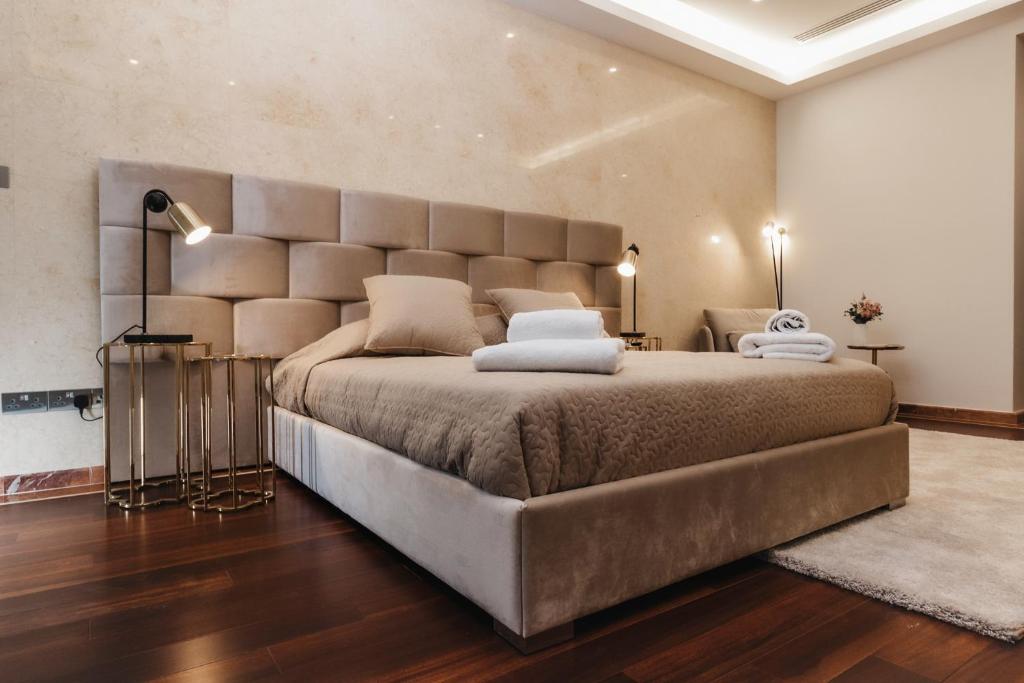 a bedroom with a large bed with a large headboard at 16 EXECUTIVE SUITES in Nicosia