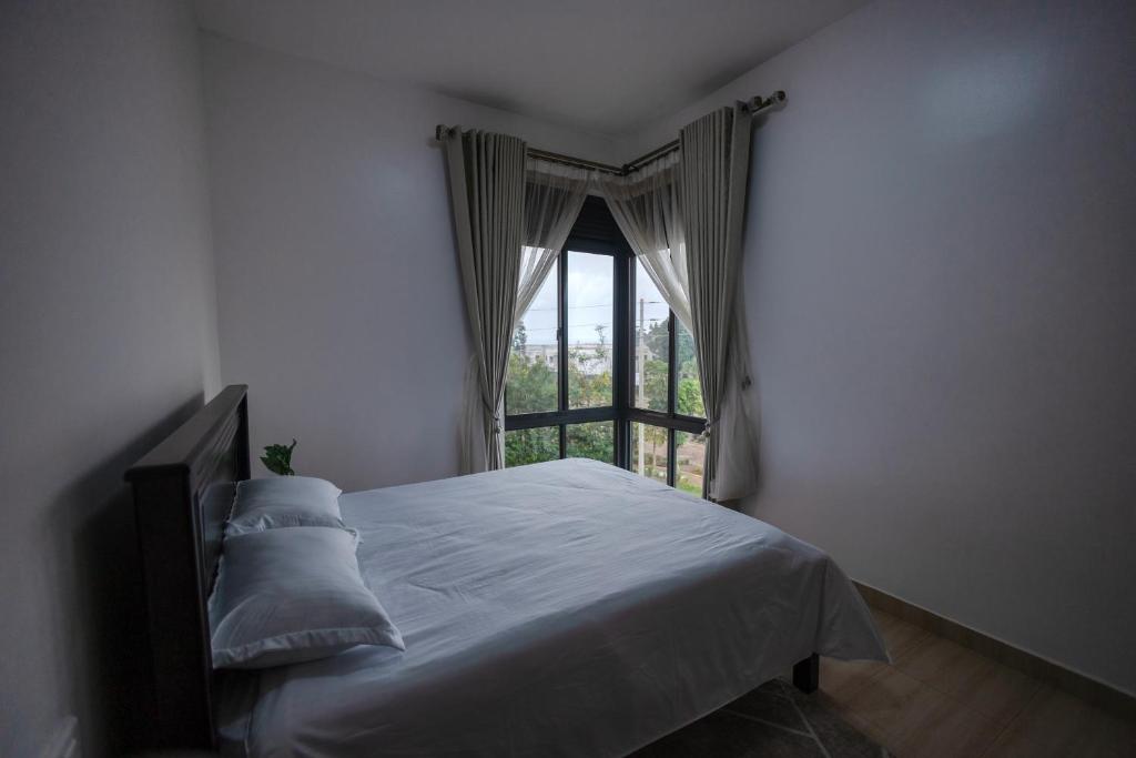 a bedroom with a bed and a window at 1 Bedroom Lake Victoria View Apartment in Entebbe
