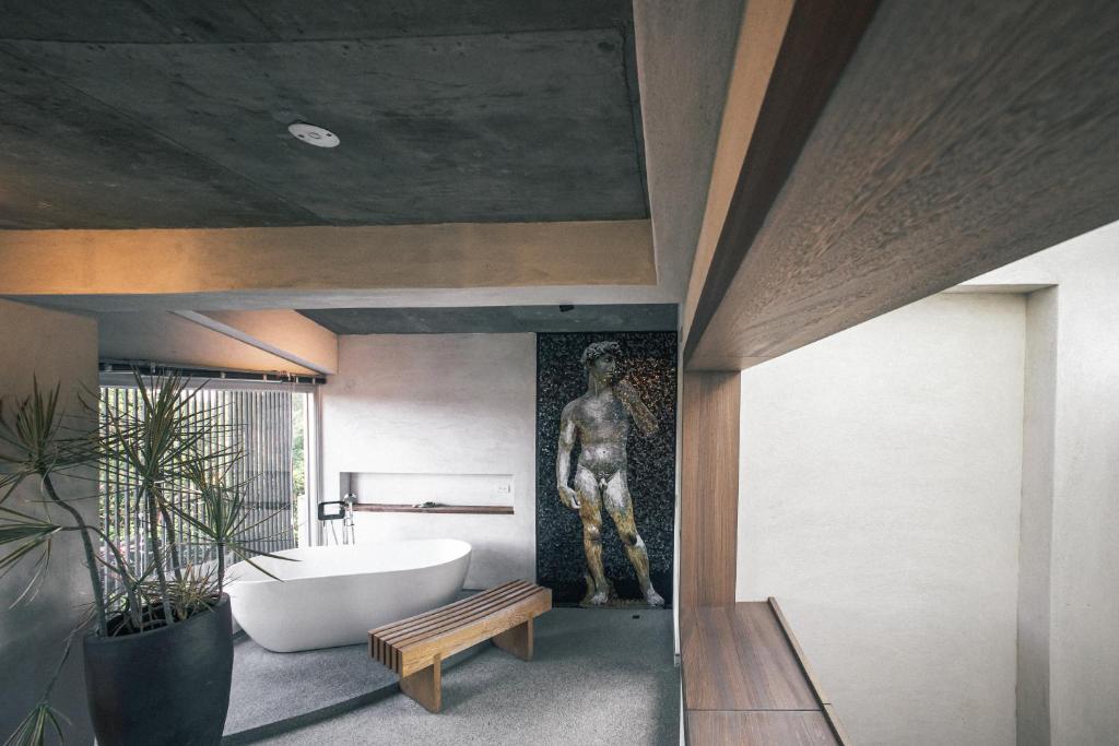 a bathroom with a bath tub and a statue at 57villa in Hengchun South Gate