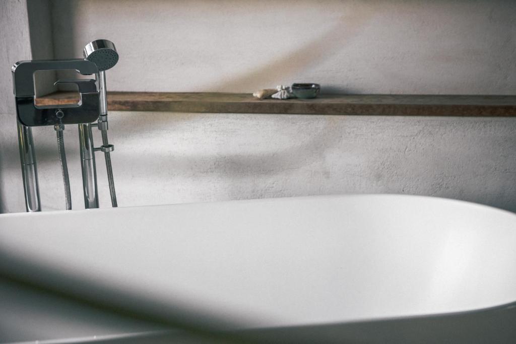 a white bath tub in a bathroom with a camera at 57villa in Hengchun South Gate