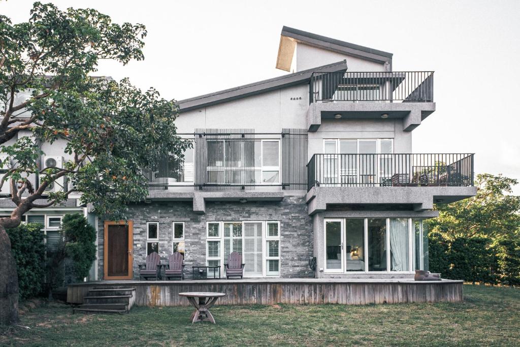 a house with a balcony and a table in the yard at 57villa in Hengchun South Gate