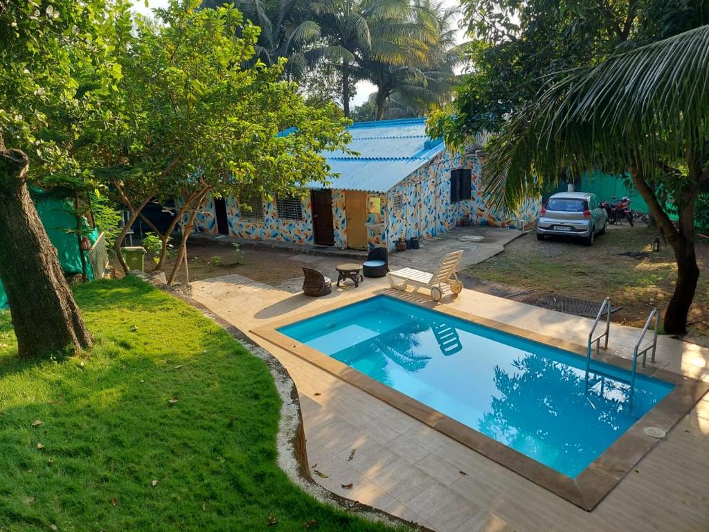 een zwembad in een tuin naast een huis bij LAKSHMI FARM in Alibaug