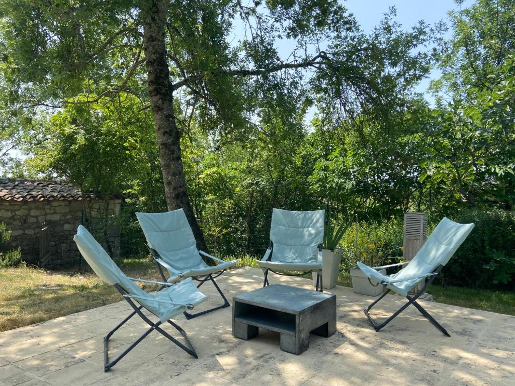 three blue chairs and a ottoman on a patio at Gîte de charme avec grand jardin &amp; piscine in Touffailles