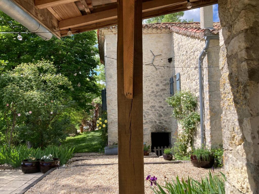 a stone house with a fireplace in a yard at Gîte de charme avec grand jardin &amp; piscine in Touffailles