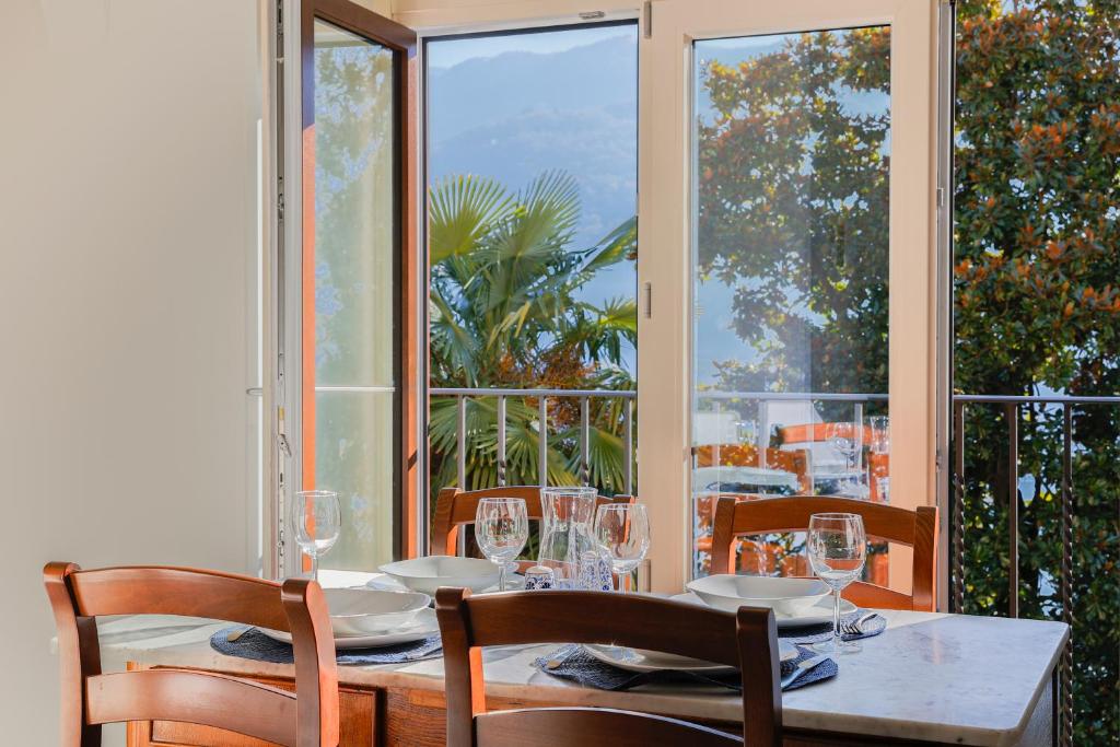 uma sala de jantar com mesa, cadeiras e janelas em Villa Eugenia Suite - by MyHomeInComo em Carate Urio