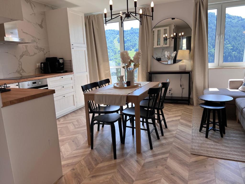 a kitchen and dining room with a table and chairs at Apartament Czeremcha in Szczawnica