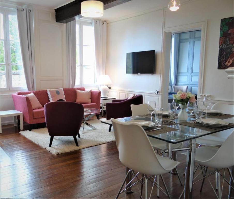uma sala de estar com uma mesa e cadeiras e um sofá em Le Cardinal em Chartres