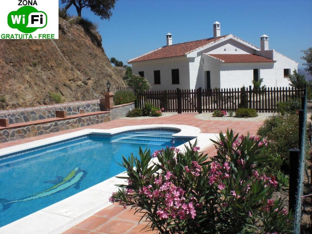 a villa with a swimming pool and a house at El Emigrante in El Chorro