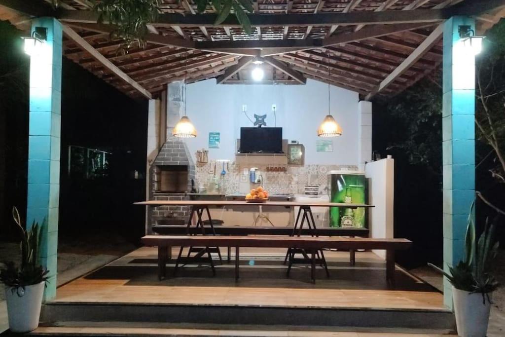 einen Picknicktisch in einem Pavillon mit einem Tisch in der Unterkunft Chácara Refúgio de Assis in Pirambu