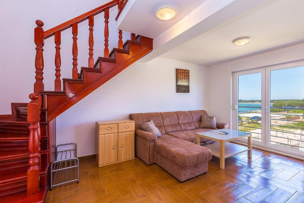 ein Wohnzimmer mit einem Sofa und einer Treppe in der Unterkunft Apartment Sammy in Medulin