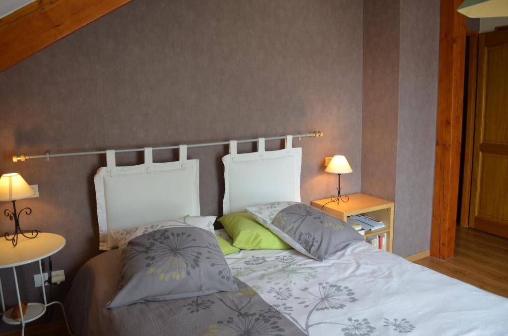 een slaapkamer met een bed met 2 kussens erop bij Chambre d'Hôtes Plesnois 