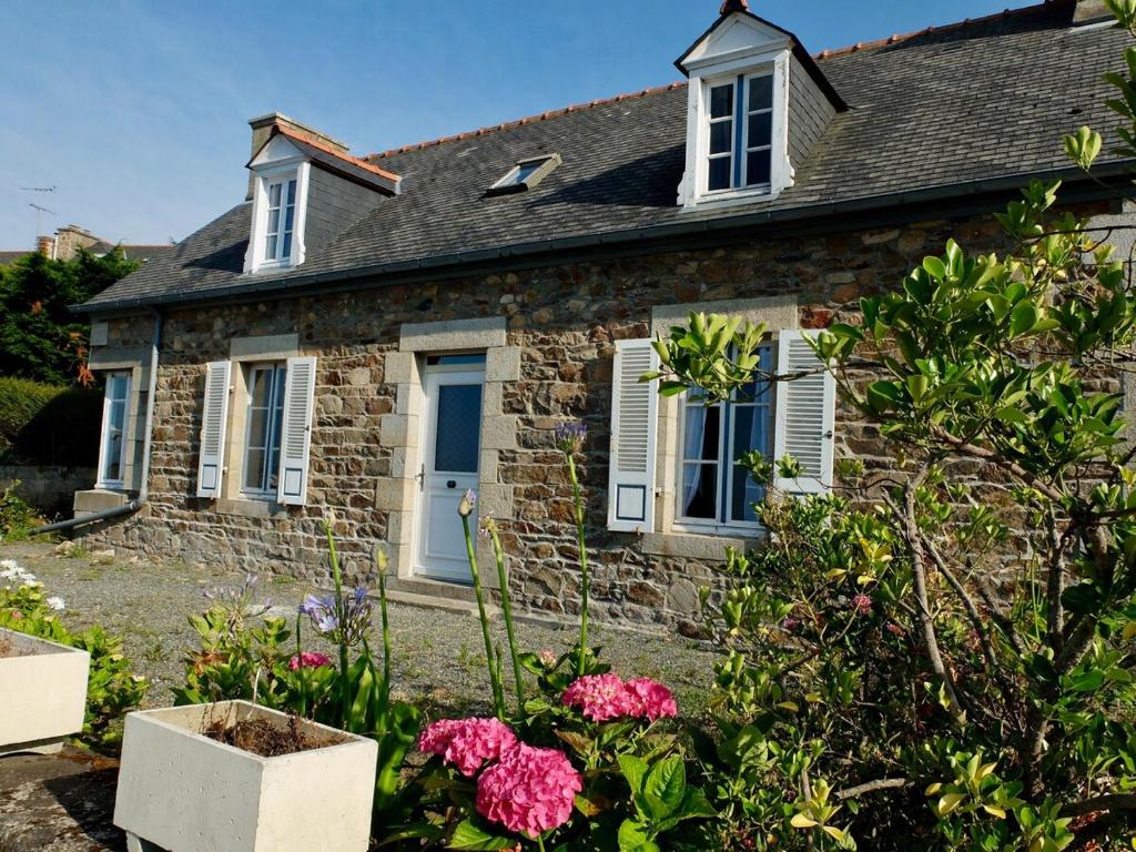 uma casa de pedra com flores em frente em Maison de pêcheur Loguivy de la mer em Ploubazlanec