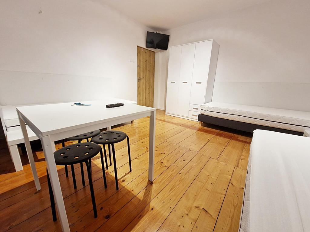 a room with a white table and two stools at Noclegi Kielce - Dom nad rzeką in Kielce