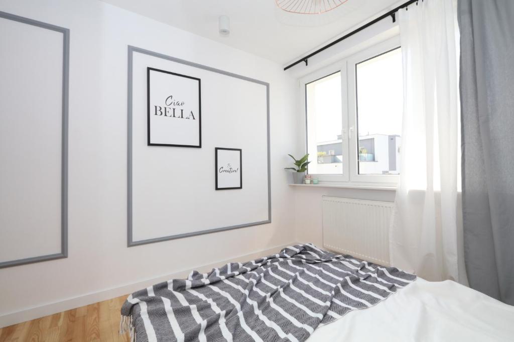 biały pokój z łóżkiem i oknem w obiekcie ''Słodowiec Residence'' Żoliborz Bielany BEDROOM Private Host w Warszawie