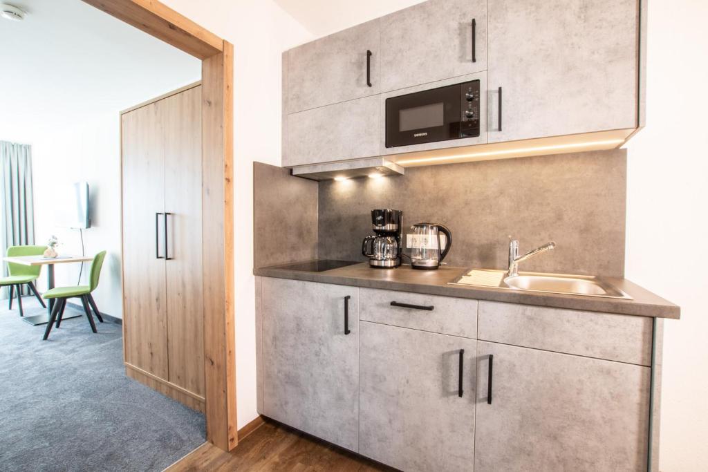 a kitchen with a sink and a microwave at Alpengasthof Hörnlepass in Riezlern