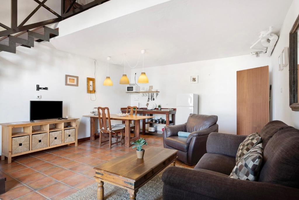 een woonkamer met een bank en een tafel bij Finca Emblemática - Nº2 Chibusque in La Vegueta