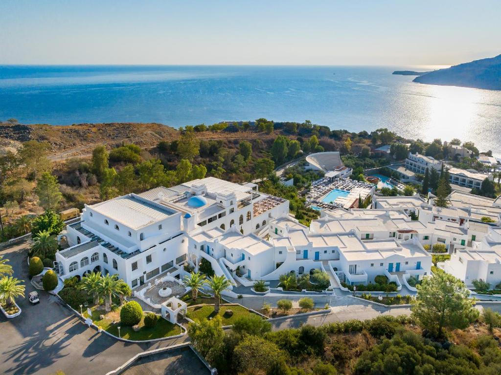 - une vue aérienne sur un grand bâtiment blanc à côté de l'eau dans l'établissement Lindos Village Resort & Spa - Adults Only, à Lindos