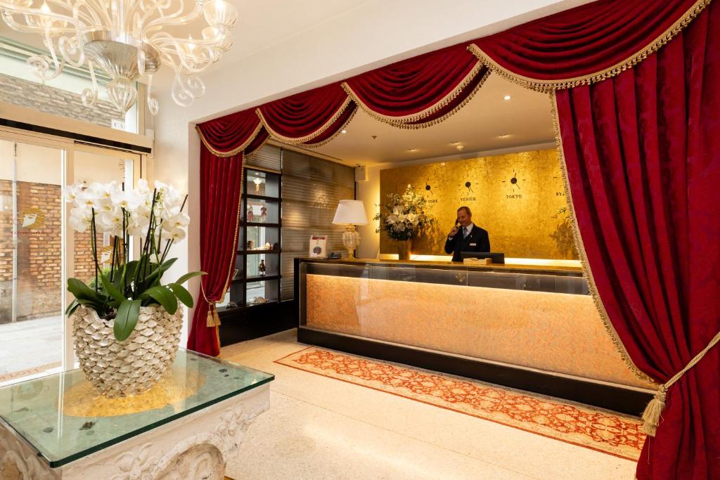 a man sitting at a desk in a hotel lobby at Hotel A La Commedia in Venice