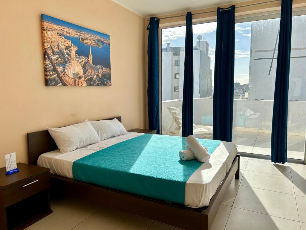ein Schlafzimmer mit einem Bett und einem großen Fenster in der Unterkunft Malta Paradise Central Accomodation in St Julian's