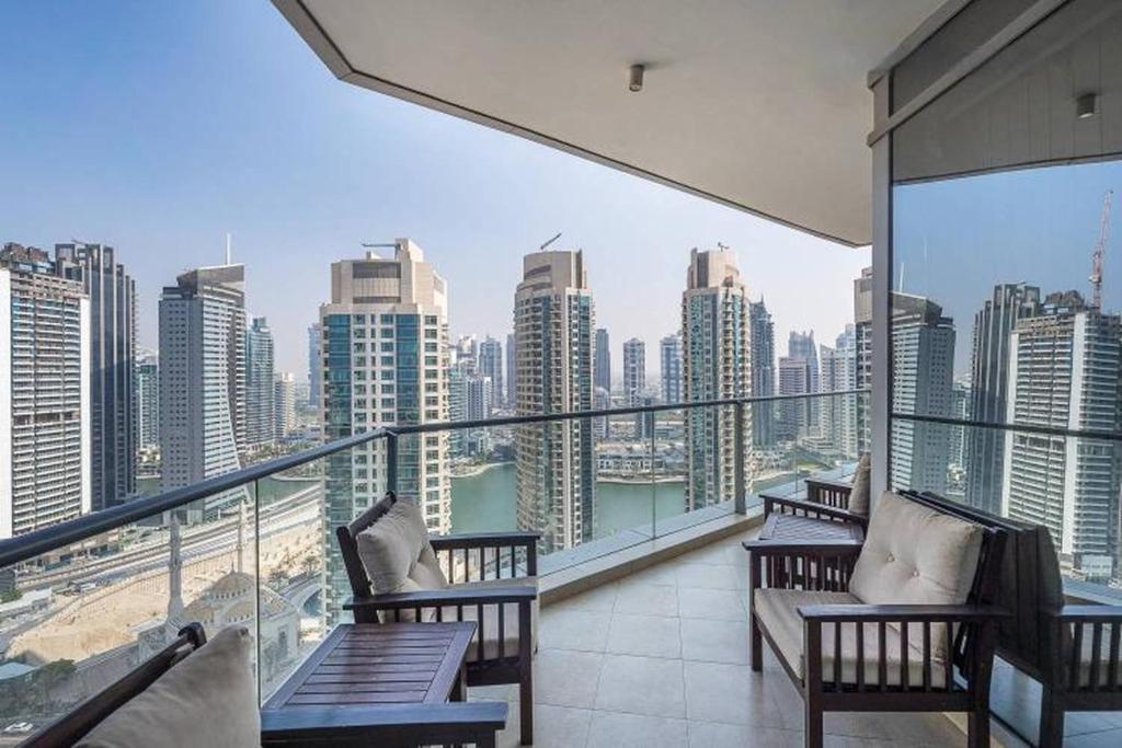 a balcony with benches and a view of a city at Trident Grand Residence,Dubai Marina - 3BR Apartment - Allsopp&Allsopp in Dubai