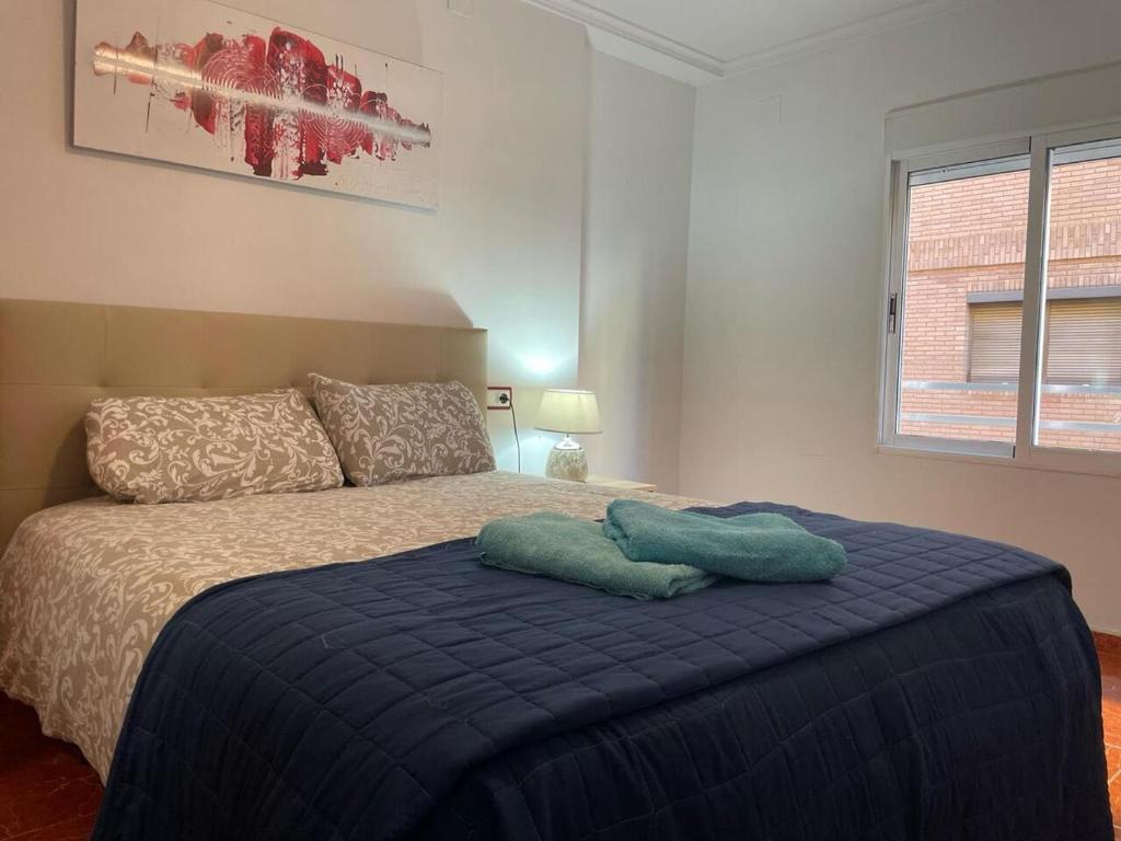 1 dormitorio con 1 cama con manta azul en Germanies Home, Algemesi Home, en Algemesí