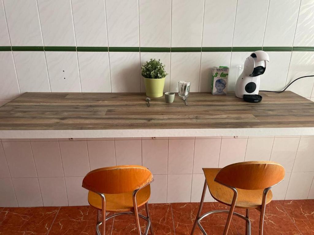 a counter with two chairs and a panda bear on it at Germanies Home, Algemesi Home in Algemesí