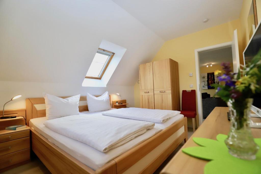 a bedroom with a bed and a vase of flowers at Haus Sonne Ferienwohnung 5 in Thiessow