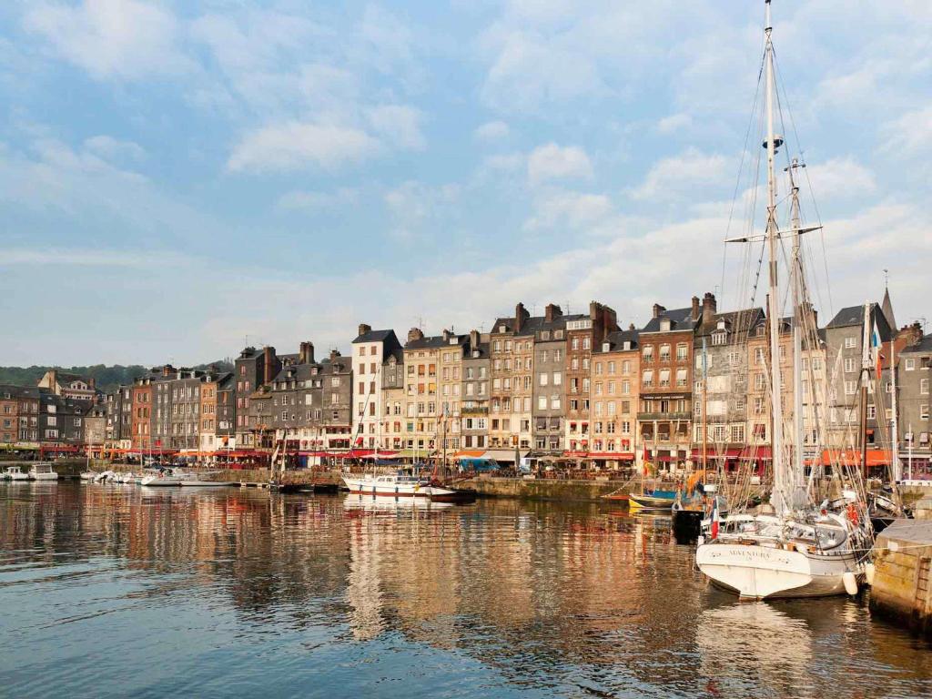 a group of boats docked in a harbor with buildings at ibis Honfleur in Honfleur