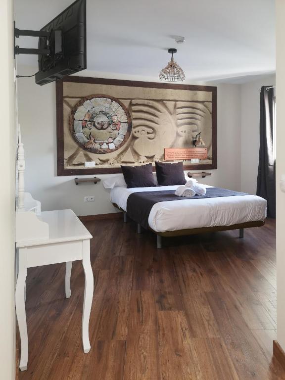 a bedroom with two beds and a tv on the wall at El Indio Chocolatería Boutique in Pinto