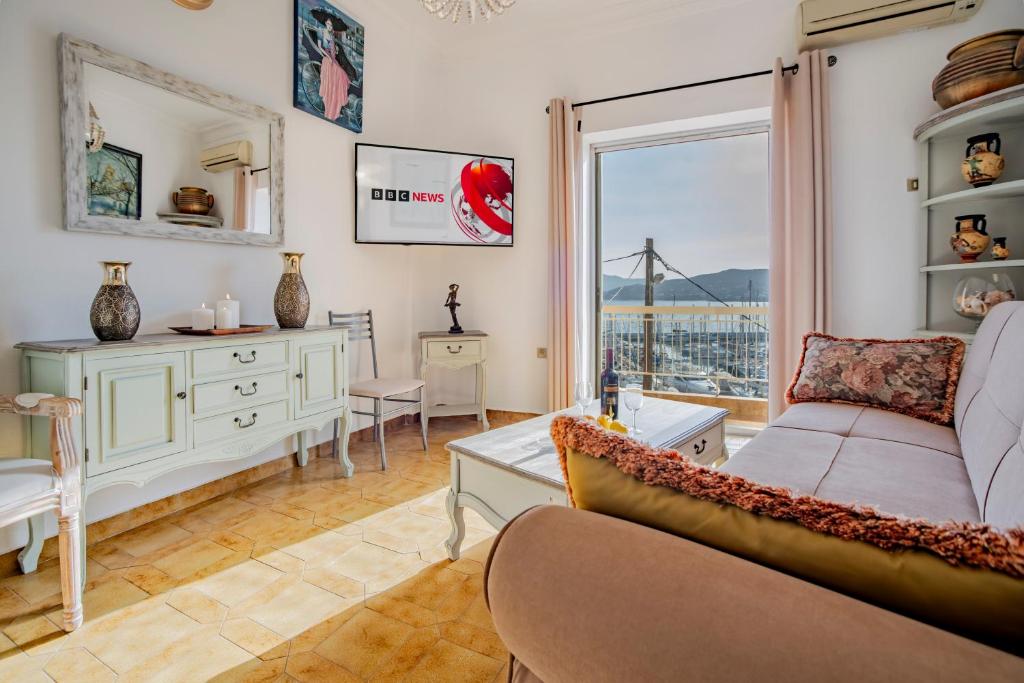 a living room with a couch and a window at Jelena Apartments By The Sea in Agios Nikolaos