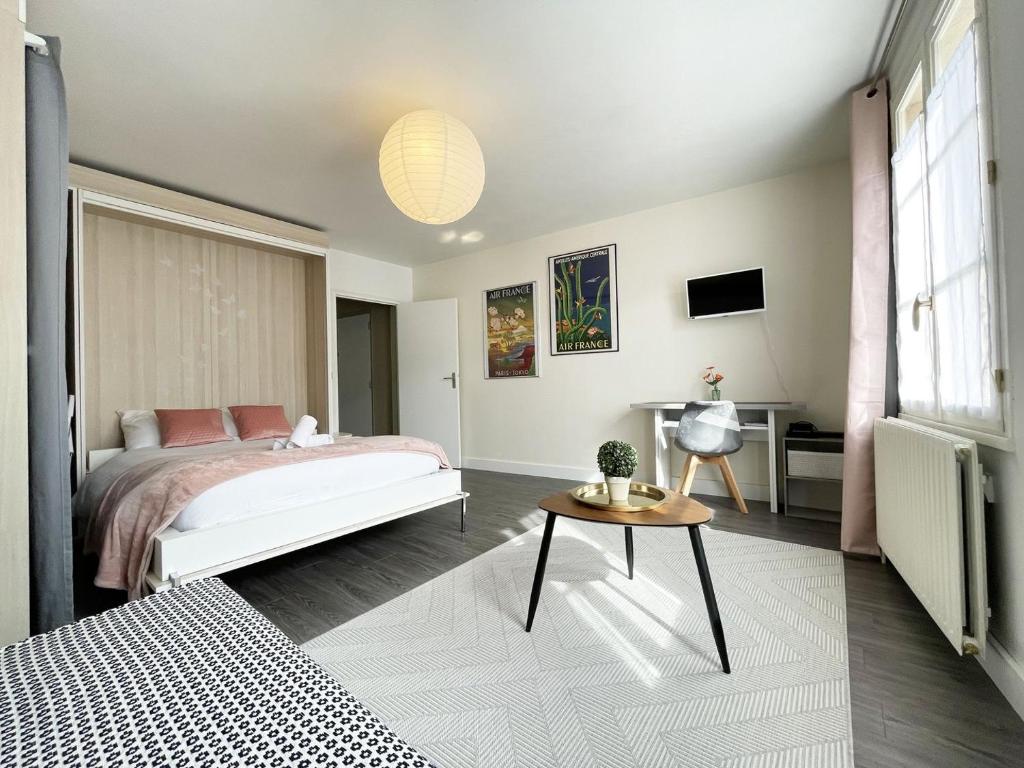 1 dormitorio con 1 cama y 1 mesa en L'aviateur - self check in, en Chartres