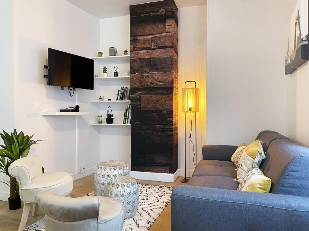 un salon avec un canapé bleu et des chaises dans l'établissement Le Grand Rapporteur, à Chartres