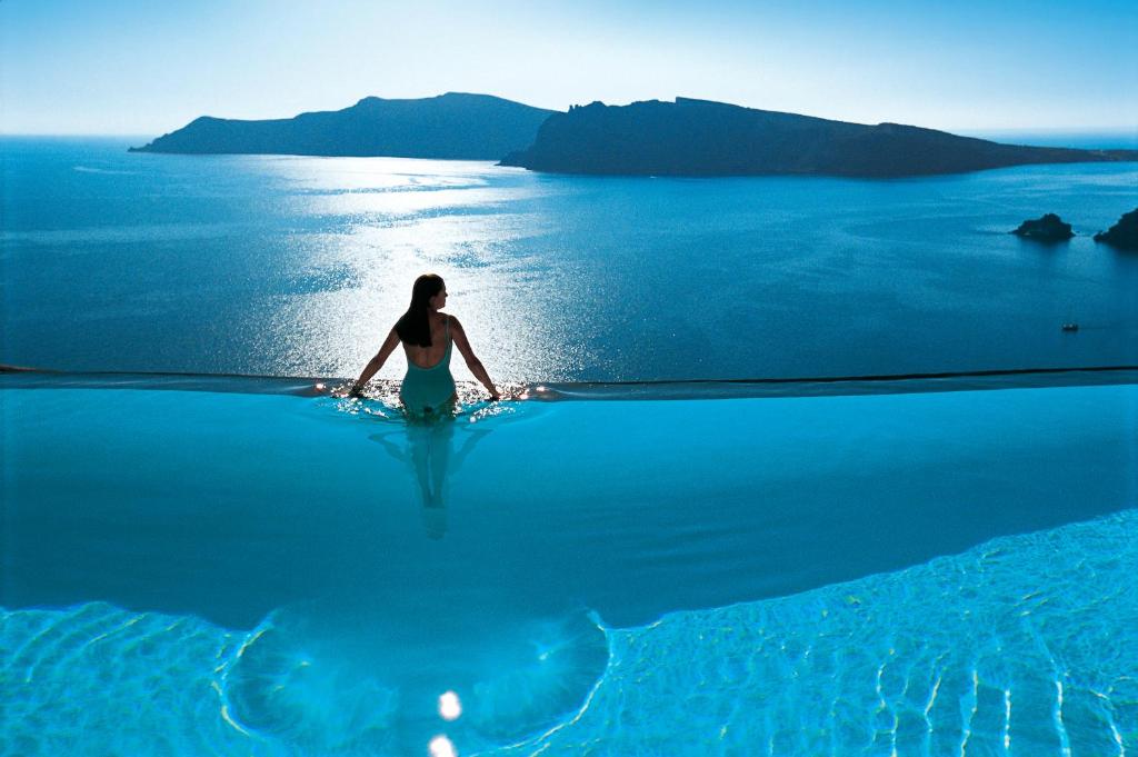 a woman standing in the water in the ocean at Perivolas Hotel in Oia