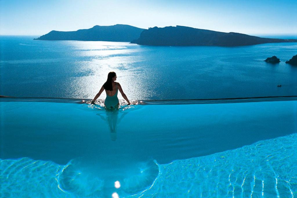 een vrouw in het water in de oceaan bij Perivolas Hotel in Oia