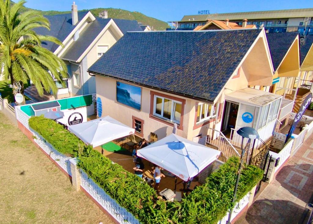 una vista aérea de una casa con mesas y sombrillas en Escuela de Surf WAVES SOUND - Alojamiento Compartido, en Santoña