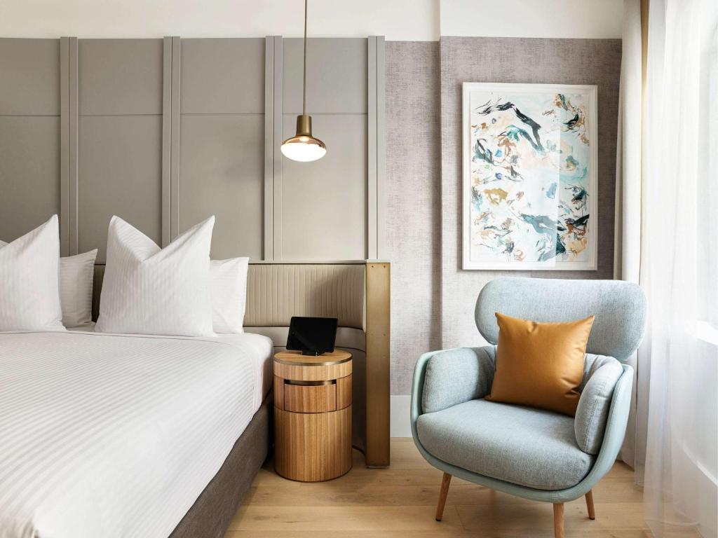 ein Hotelzimmer mit einem Bett und einem Stuhl in der Unterkunft The Porter House Hotel Sydney - MGallery in Sydney