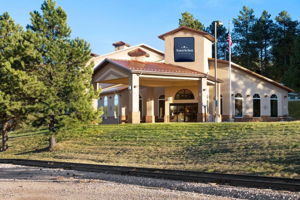 a building with a sign on the front of it at AmericInn by Wyndham Hill City Mt Rushmore in Hill City