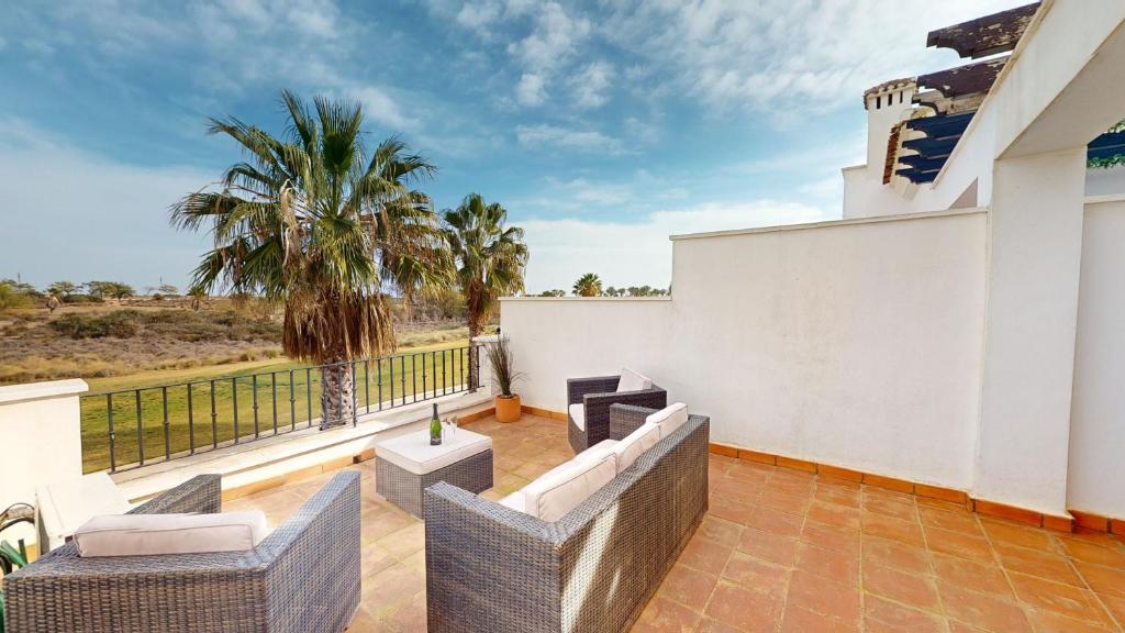un balcón con sillas, mesas y una palmera en Casa Esturion A-Murcia Holiday Rentals Property, en Roldán